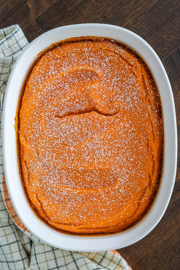Picadilly carrot souffle baked in a white ceramic dish and dusted with powdered sugar.